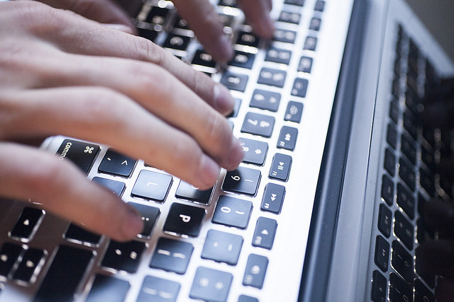 Fingers typing on laptop keyboard