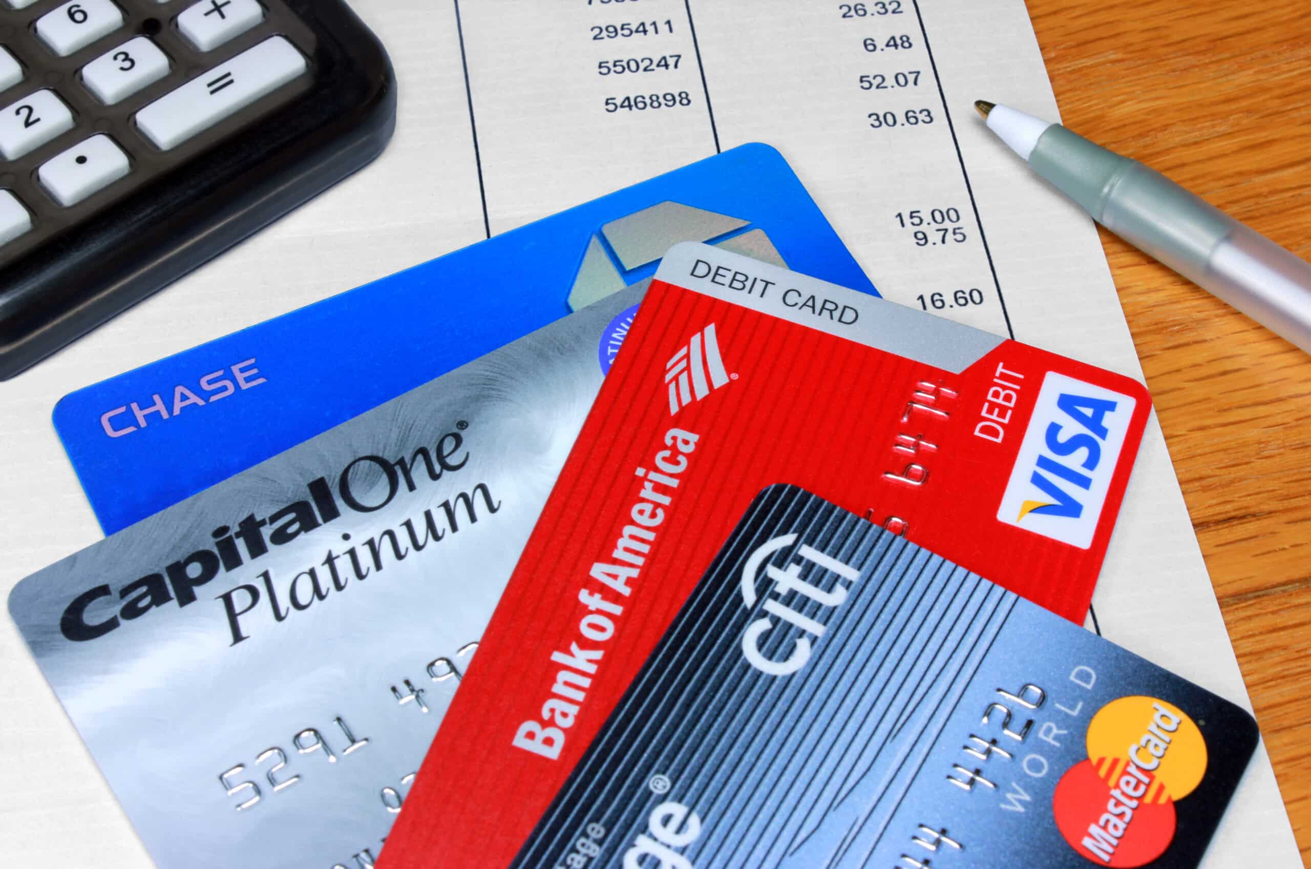 Credit and debit cards on financial statement with calculator and pen
