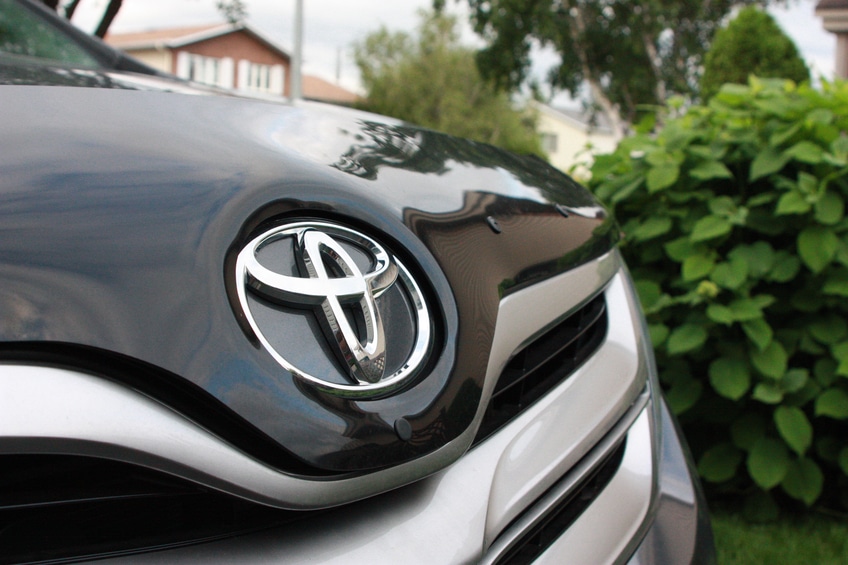Chrome Toyota logo on dark gray car grille with silver accents