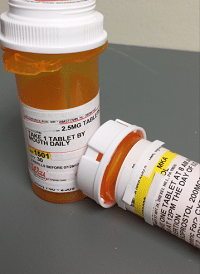Two orange prescription bottles with dosage instructions on labels