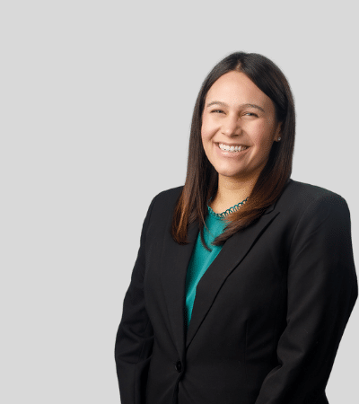 Jordan E. Jacobson image Woman with long dark hair, black blazer, smiling.