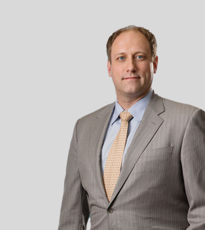 Daniel Albert bio image Man in light gray suit with tie, neutral expression.