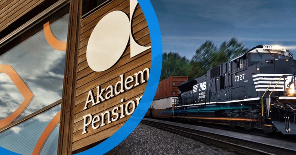 Train passing an “Akademie Pension” advertisement sign.