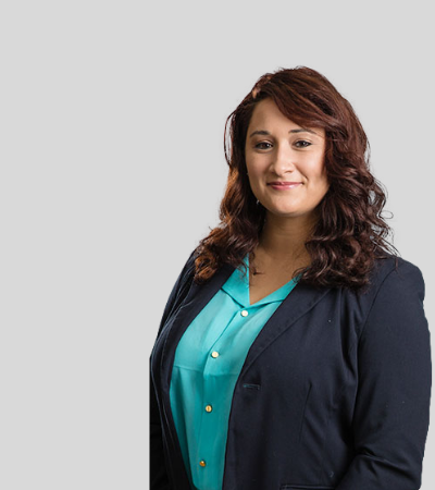 Sara Riegel: Studio portrait of a woman with curly hair wearing teal blouse