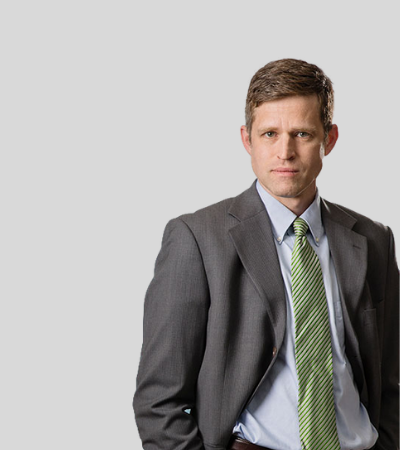 Steven D. McLain: Studio portrait of a man in gray suit with green tie