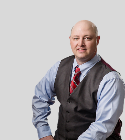 Michael P. Steinbrecher: Studio portrait of a bald man wearing vest and dress shirt