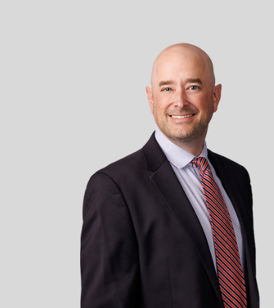 Andrew M. Peoples: Studio portrait of a bald man in dark suit smiling