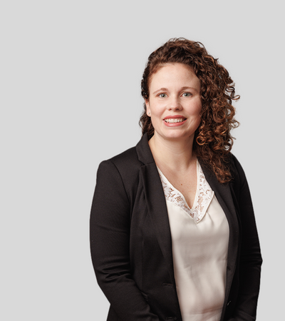 Kathleen McGuigan: Studio portrait of a woman with curly hair wearing dark blazer