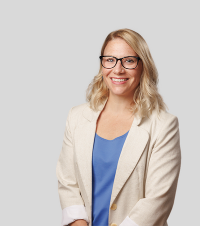 Katelyn A. Rosenberg: Studio portrait of a woman wearing glasses and beige blazer