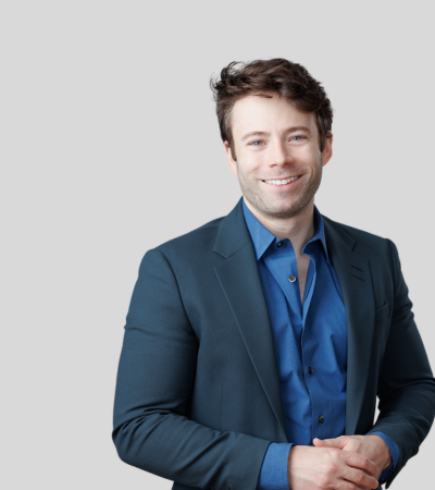 Sean McIntyre: Studio portrait of a man in blue jacket smiling
