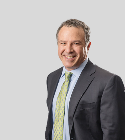 Marc A. Topaz Bioimage Man in dark suit with green tie, smiling.