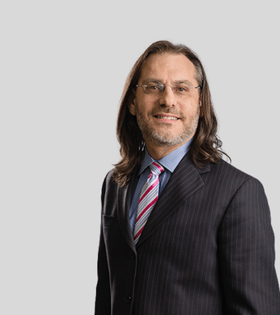 Eric L. Zagar bioimage: Studio portrait of a man with shoulder-length hair wearing suit