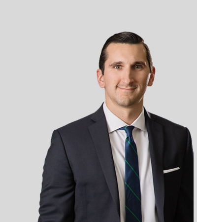 Jonathan F. Neumann bioimage Man in navy suit with green tie, smiling.