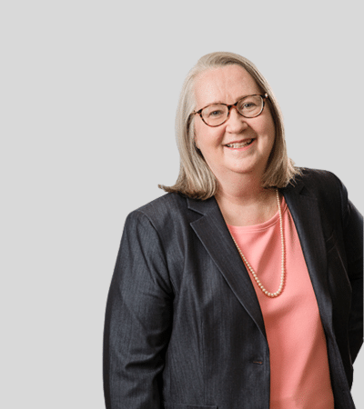 Donna K. Eagleson: Studio portrait of a woman wearing glasses and blazer