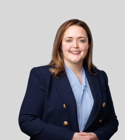 Emily N. Christiansen Bioimage Woman in navy blazer over light blouse, smiling.