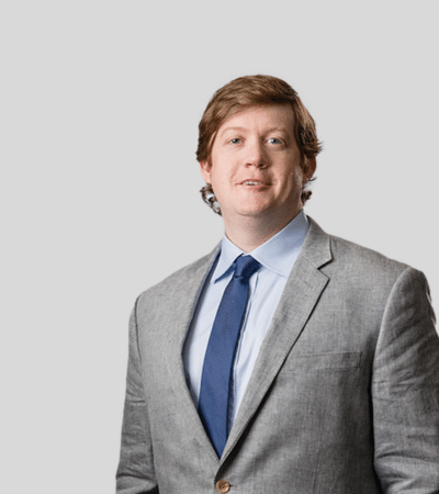 Ryan T. Degnan image Young man with light brown hair in gray suit and blue tie, neutral expression.