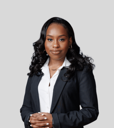 Mariama Barry bioimage: Studio portrait of a woman in black blazer with folded hands