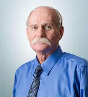 Kurt W. Weiler Older man with mustache in blue shirt and tie, neutral expression.