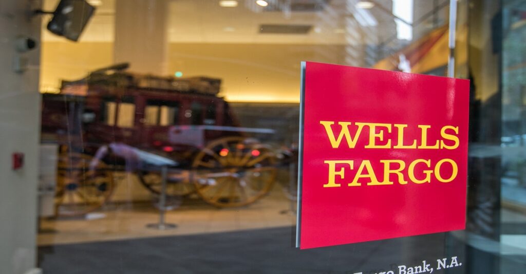 Wells Fargo logo on a glass door with a historic wagon in the background.
